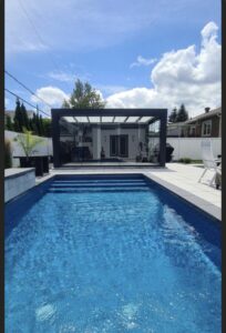 Modern villa bahçesinde havuz yanında cam kapalı kış bahçesi pergola sistemi